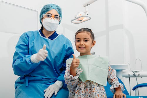 An image of a woman in scrubs with a little girl
