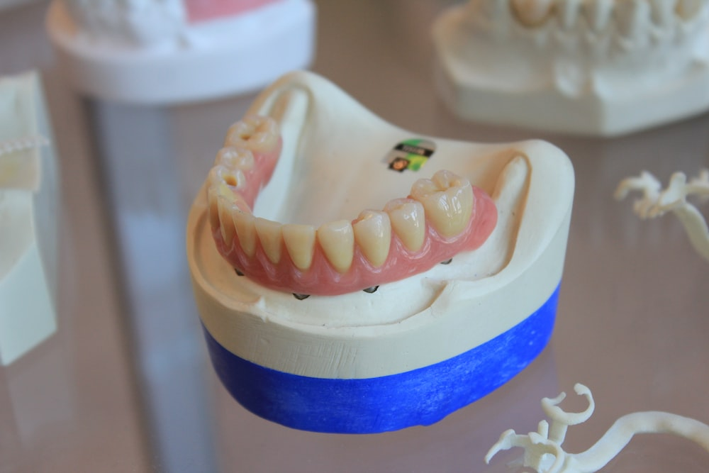 An image of dentures on a white scale rack
