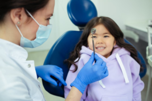 An image of a dentist showing a dental tool to a kid