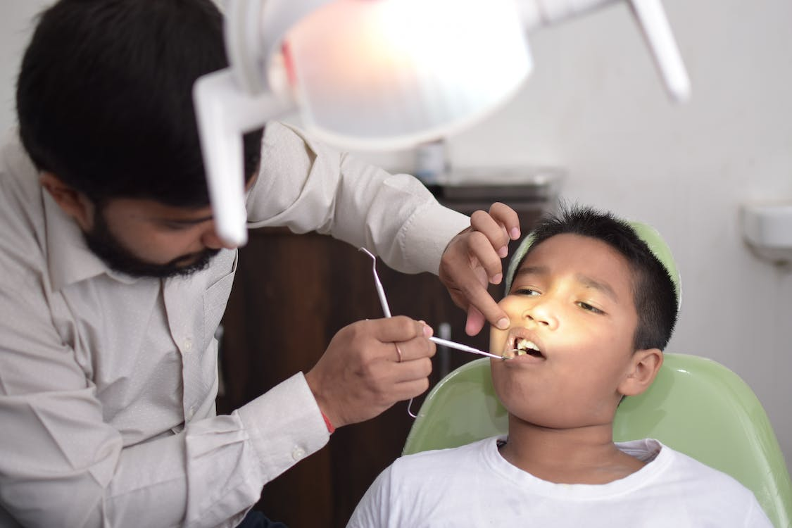An image of a dentist treating a kid