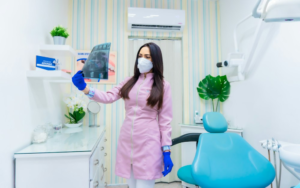 A dentist in a purple shirt looking at an X-ray
