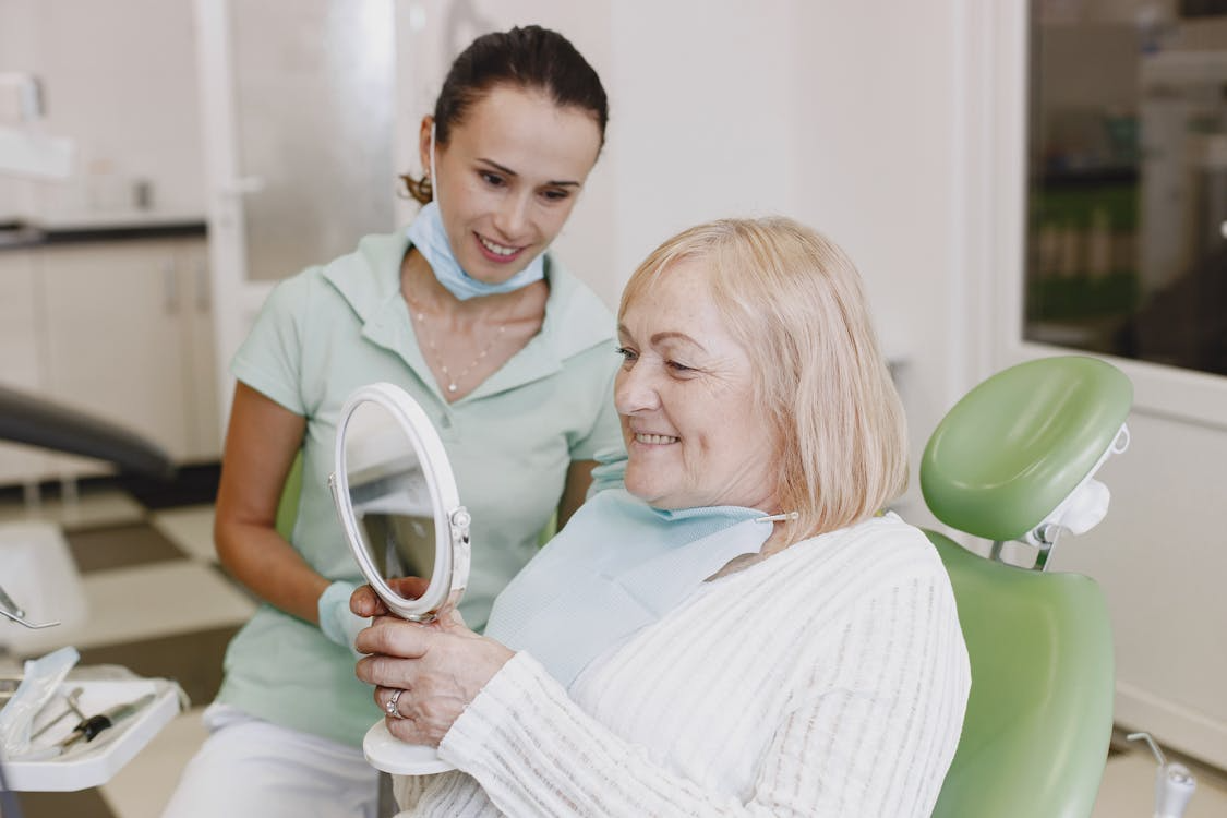 A dental practitioner looking at a satisfied patient