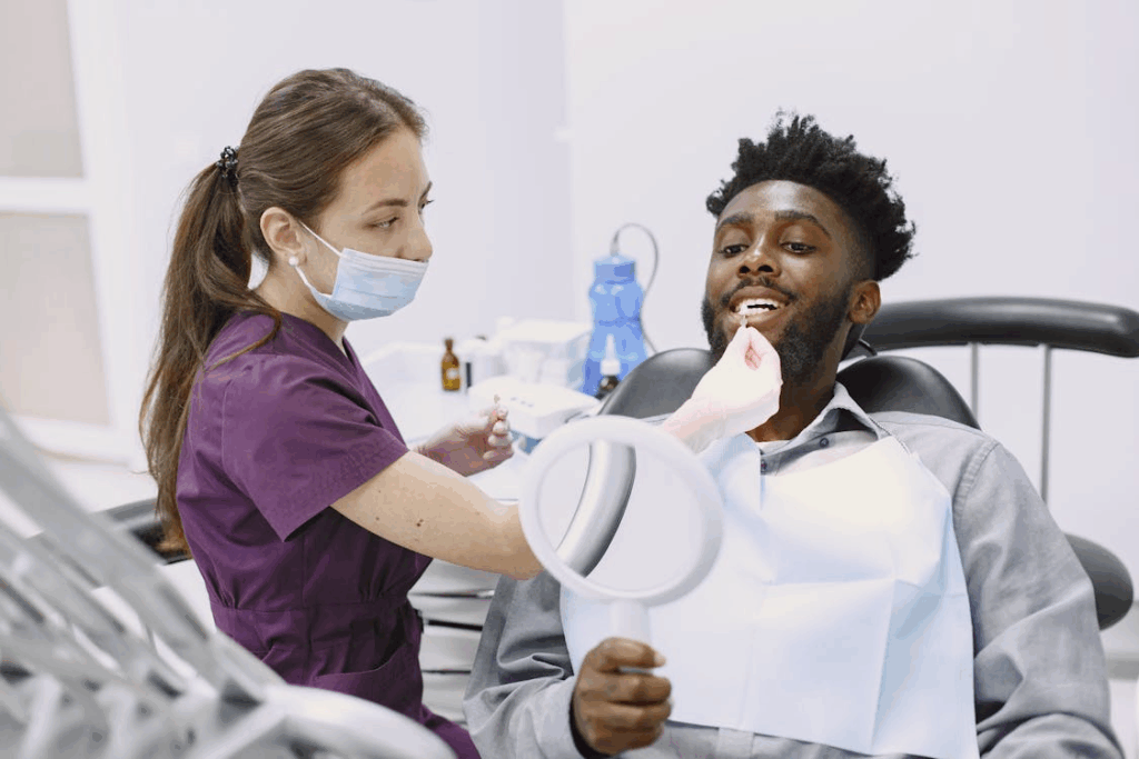 An image of a dental practitioner matching veneer shade to patient’s real teeth