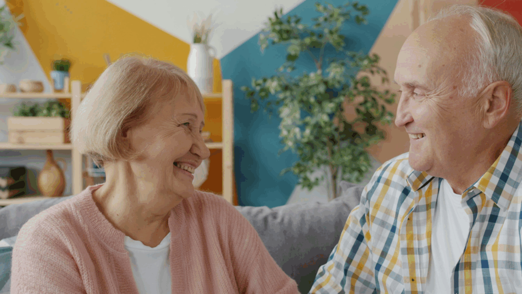 Elderly couple smiling warmly at each other