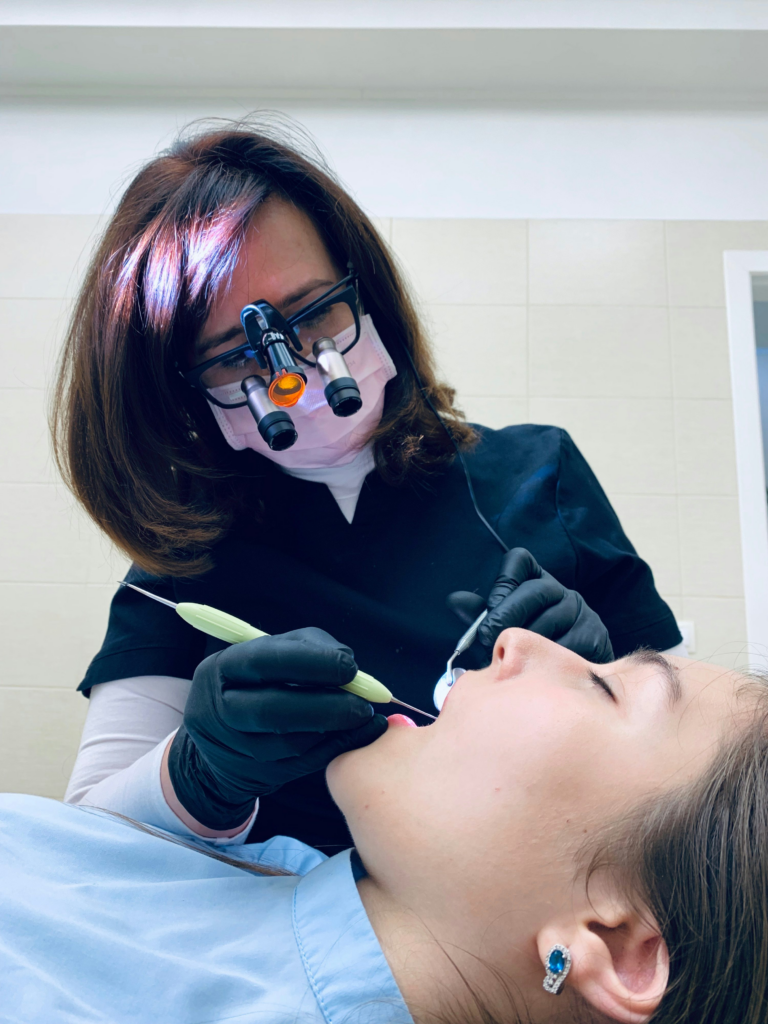 Dentist examining a patient’s mouth with clinical tools