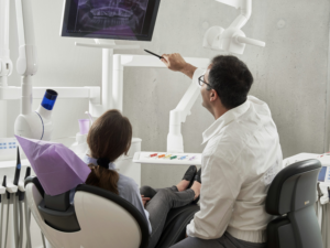 Dentist showing a patient a monitor