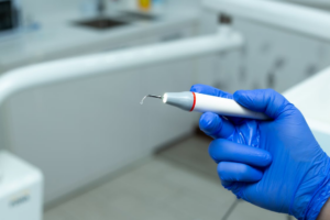 This photo shows a dentist holding a dental instrument