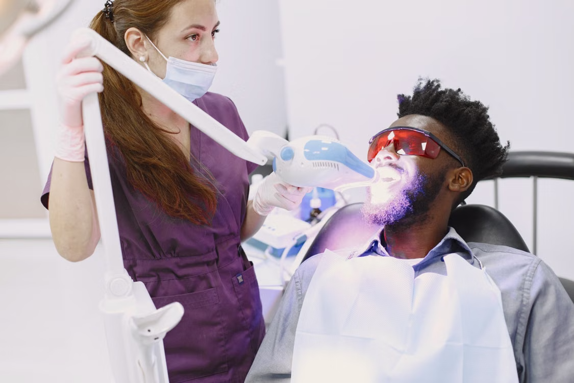 a dental provider using an LED light during a whitening treatment