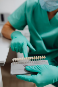 a dentist selecting a tooth shade from a shade guide